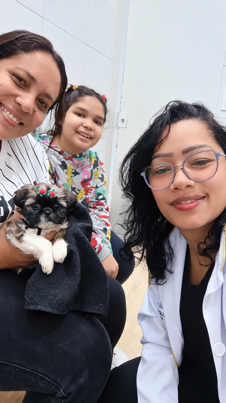 Dra. Elayne com uma família e um cão pequeno